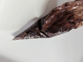 淡奶油加巧克力隔热水融化成液体，装入裱花袋，在尖端剪一个小口子。