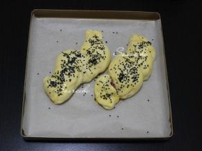 发酵好的面团变至原来的2陪大，取出，表面图一层全蛋液，撒些黑芝麻。