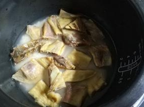 将鸭身块码入米水面里，按香弹煮功能键，开始煮饭