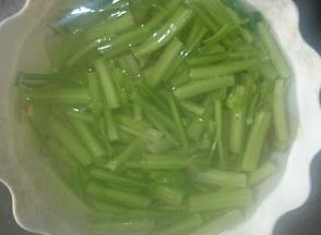 首先把芹菜用热水烫一下。