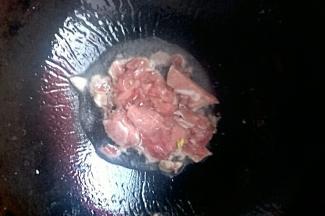 锅中倒油开小火，油温七成热放入猪肉开大火炒熟