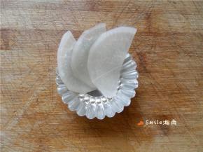 将白萝卜片顺时针摆在模具中。