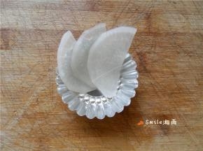 将白萝卜片顺时针摆在模具中。