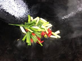 锅烧热油，爆香蒜苗和小米辣