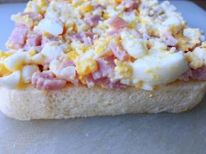 取一片吐司，将火腿鸡蛋涂厚厚的一层 ，再盖上另一片吐司