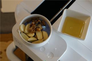 按提示将玉米油及蒜头还有鱼干丁下锅爆香。