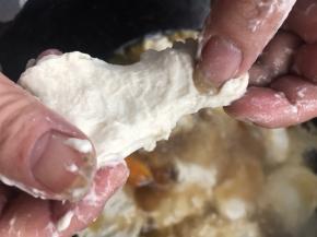 把手沾上水，揪一小团面团，捏成饼