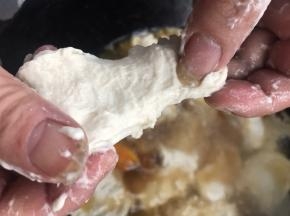 把手沾上水，揪一小团面团，捏成饼