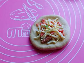 取一块面团，用擀面杖擀圆饼，再放上准备好的芝士馅料。