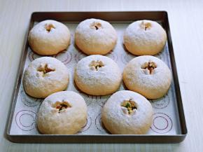 取出发酵好的面包胚，是原来的1.5倍大，筛上一层高筋面粉，用剪刀剪十字口，把4个口角往外拉一下。