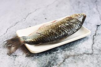 将鲫鱼刮鳞、去除内脏，清洗干净，沥干水分，在鱼的两面用到划几刀，方便入味。