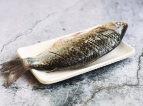 将鲫鱼刮鳞、去除内脏，清洗干净，沥干水分，在鱼的两面用到划几刀，方便入味。