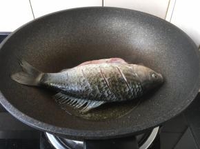 锅烧热后放入2勺的食用油，油温五、六成热时放入鲫鱼。