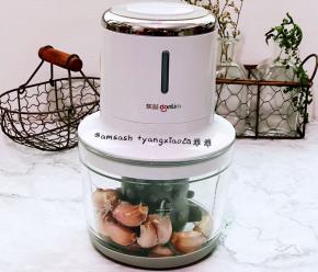 把掰好的蒜头放入料理机中，用到剥蒜器来剥掉蒜的外皮