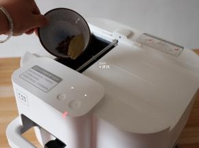 预热结束后根据提示从投料口放入植物油、八角、香叶、干辣椒，投料完毕后点击开始键进行翻炒；