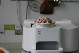 按提示预热锅，将玉米油及肉丁下锅爆香至出油。