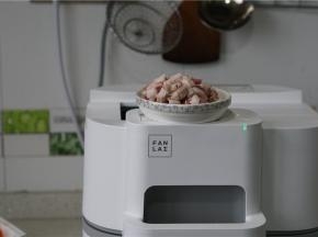 按提示预热锅，将玉米油及肉丁下锅爆香至出油。