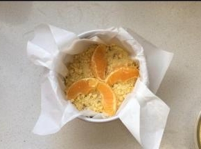 预留的大块橙子瓣摆放在蛋糕表面上，关于装饰大家可以感觉自己喜好