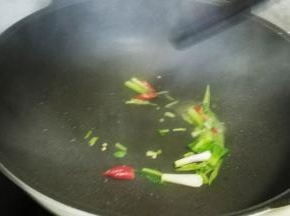 锅里热油放入葱头梗、小米椒煸香