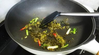 放入酸菜叶（酸菜叶先用糖腌20分钟）炒均匀