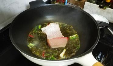 将鱼腩放入酸菜汤汁里