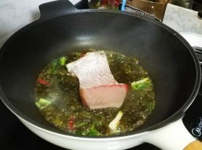 将鱼腩放入酸菜汤汁里