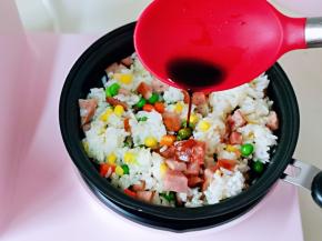 再加入一小勺生抽，提鲜，小火翻炒均匀，将米饭炒制颗颗散开。