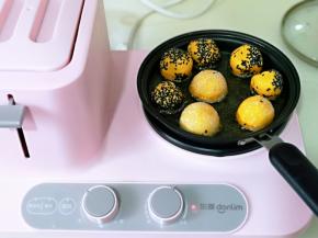 锅中加入油， 油温5成时，依次放入南瓜麻球，转小档慢炸，翻动。