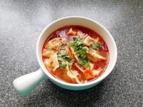 将饺子捞入碗中，加入两勺红油搅拌均匀，撒上香菜碎。