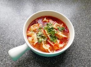 将饺子捞入碗中，加入两勺红油搅拌均匀，撒上香菜碎。