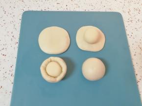 取一个油皮面团压扁，放入一个油酥面团 ，收口捏紧向下摆放，盖上保鲜膜。