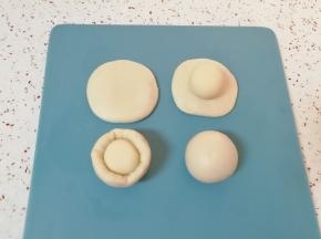 取一个油皮面团压扁，放入一个油酥面团 ，收口捏紧向下摆放，盖上保鲜膜。