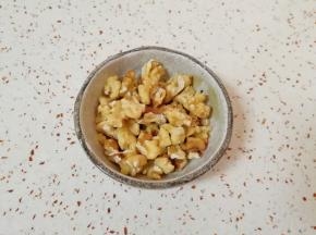 核桃仁烤熟以后趁热揉搓一下去皮(不用完全去掉)，用刀切碎。