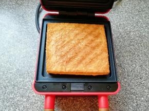 打开早餐机看到吐司变成金黄色即可。