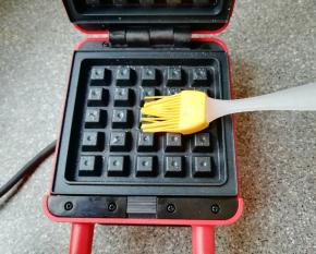 华夫饼早餐机接通电源，上下盘均匀的刷上一层食用油。