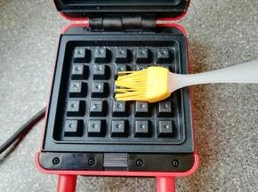 华夫饼早餐机接通电源，上下盘均匀的刷上一层食用油。