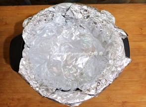 用2张锡纸，错开、平铺在砂锅里面的小圆球上面。