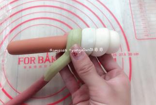 取一根火腿肠，然后拿搓好的面团，面团的一头捏薄，贴在火腿肠上，圈卷在火腿肠上面，收口压在下面再次捏紧收口