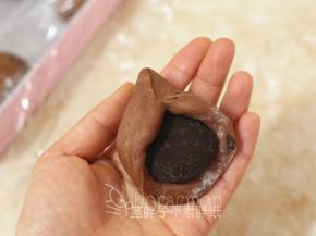 松弛好的面团压扁，包入2个巧克力币，捏紧收口，最后将面团团圆。