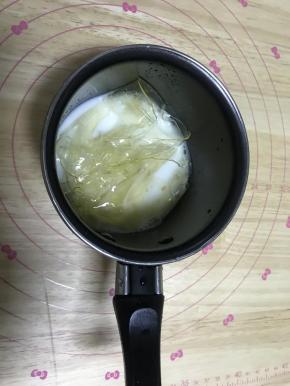 9.制作酸奶慕斯层：吉利丁用冰水泡软，和牛奶隔水加热融化。