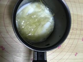9.制作酸奶慕斯层：吉利丁用冰水泡软，和牛奶隔水加热融化。