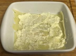 容器底部铺上一层千层面、涂上一层白酱