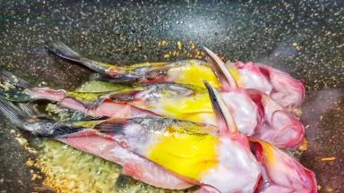 蒜香味出来了放昂刺鱼煎两面微黄，加一点料酒去腥。