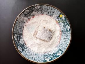 将腌制好的带鱼裹上一层粉，每一块都裹好备。
