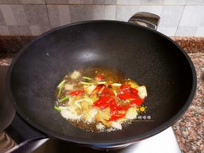 放入泡椒、泡姜、小葱、大蒜和1勺豆瓣酱翻炒出香味。