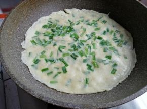 倒入面糊，转动锅，使面糊均匀地平摊在锅底，一面烙至微黄后再翻面烙，全程用中小火烙