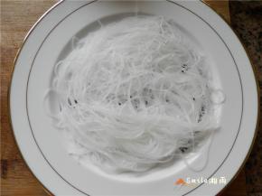粉丝沥水捞出，铺在盘中。