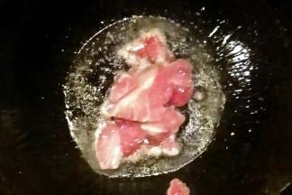 锅中倒油开小火，油温七成热开大火放入猪肉炒熟