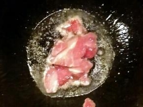 锅中倒油开小火，油温七成热开大火放入猪肉炒熟