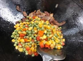 加入红萝卜、玉米粒、豌豆翻炒均匀